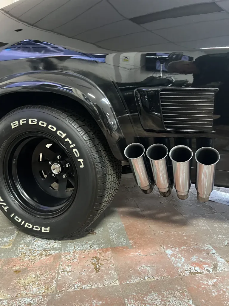 Four chrome side exhaust pipes and a BFGoodrich tyre on the black Interceptor replica