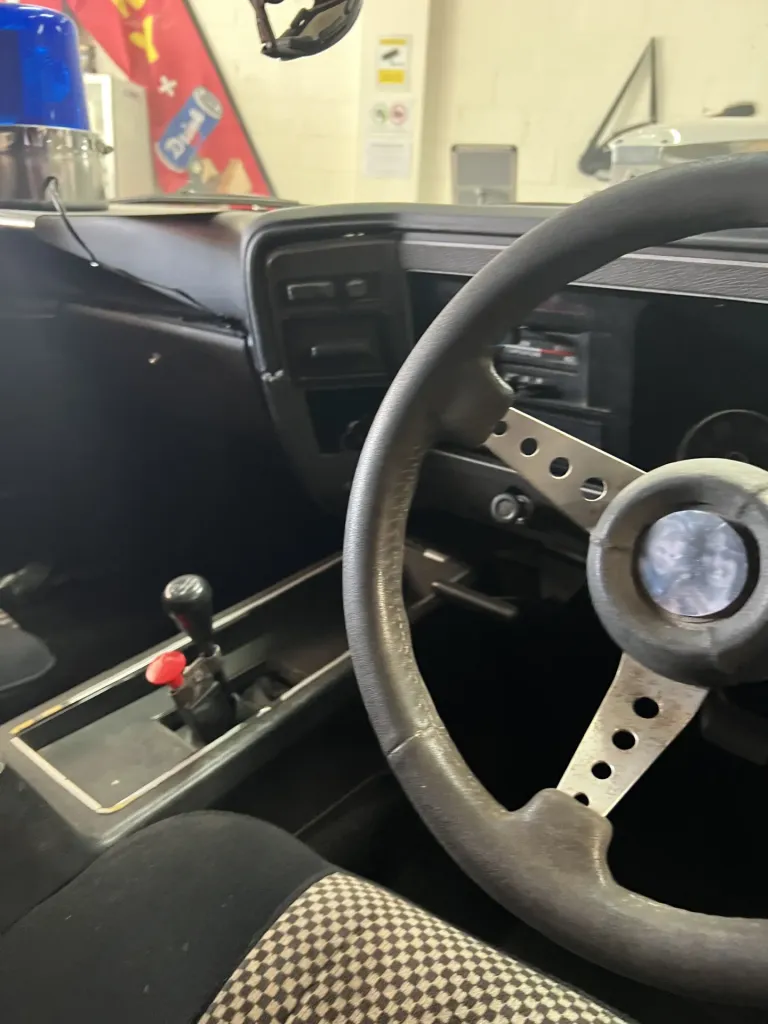 Interior of the Interceptor replica with a drilled steering wheel, red shifter switch and blue police light