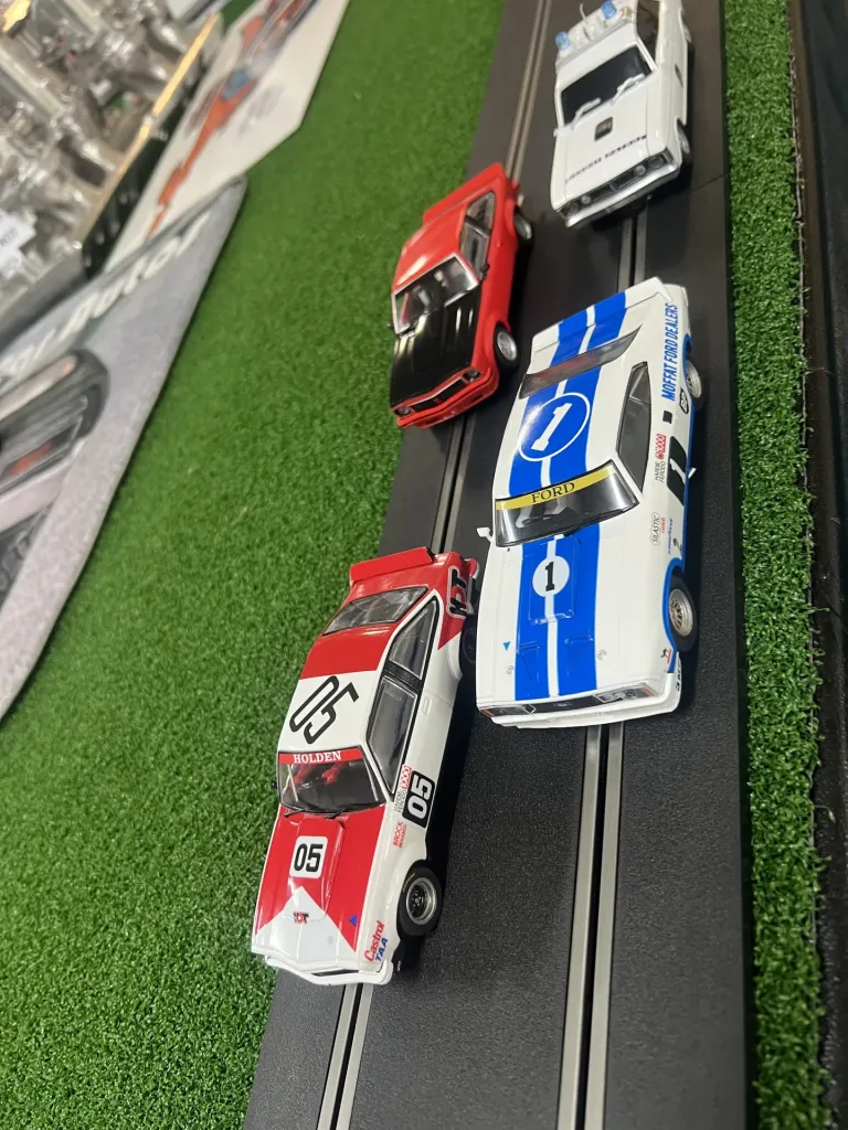 Holden 05 and Ford number 1 model race cars side by side on the Scalextric track